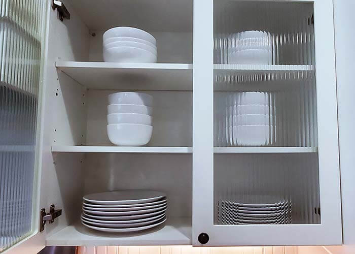 White dishes neatly organized in cabinet