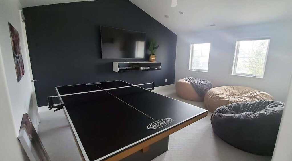 Game room with TV, bean bag chairs, and ping pong table.