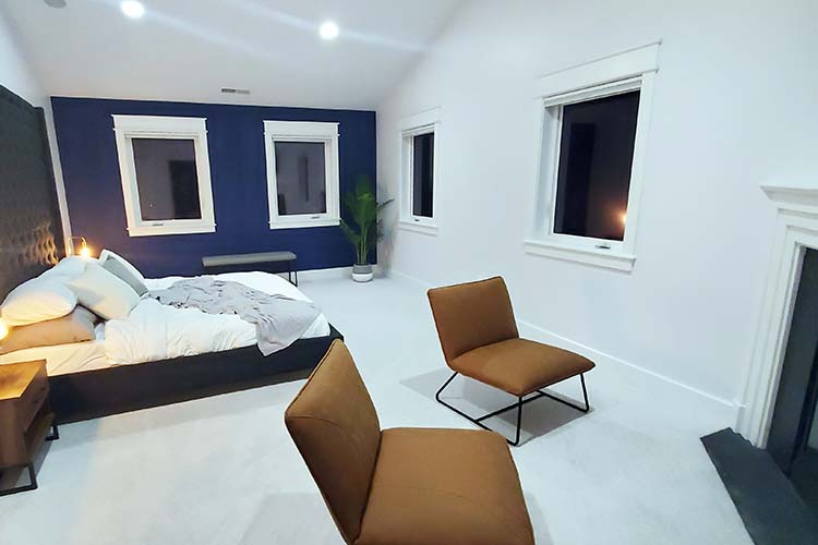 Master bedroom with dark blue accent wall and minimalist furniture